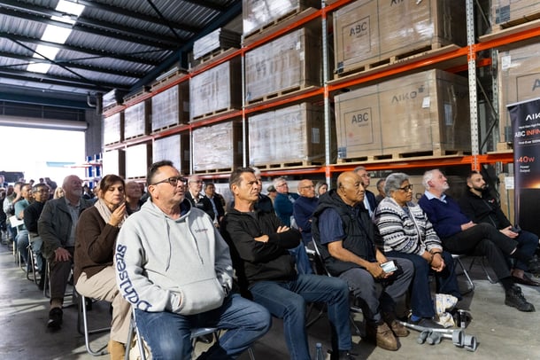 Attendees listening to a presentation at the Smart Energy Innovation Showcase in a warehouse setting.