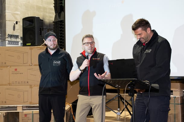 Smart Energy Answers CEO Daniel speaking alongside Vahan Verisan, owner of Highland Security Services, and a member of his team at the Smart Energy Innovation Showcase.